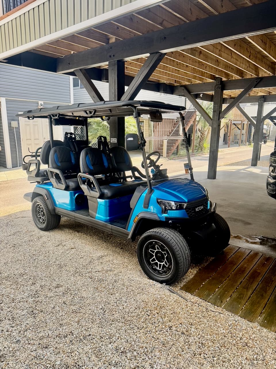 Ocean Echoes golf cart parked under the carport